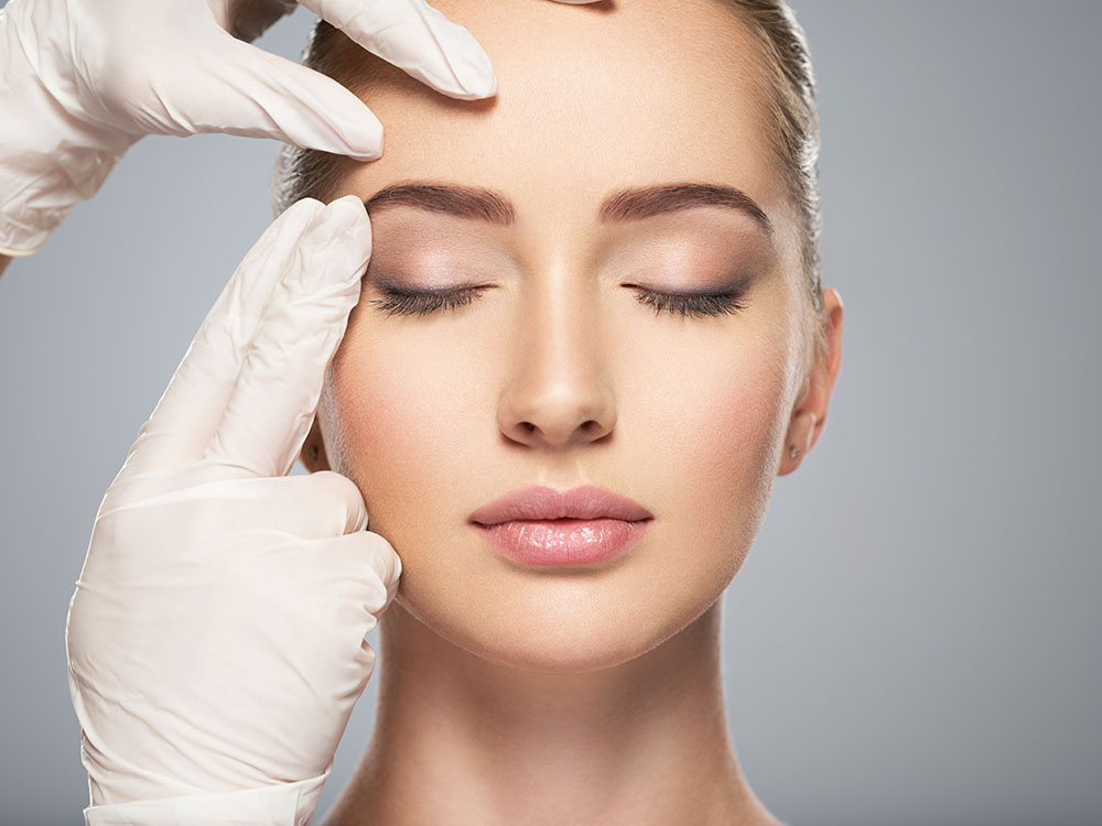 skin check before plastic surgery. Beautician touching woman face.