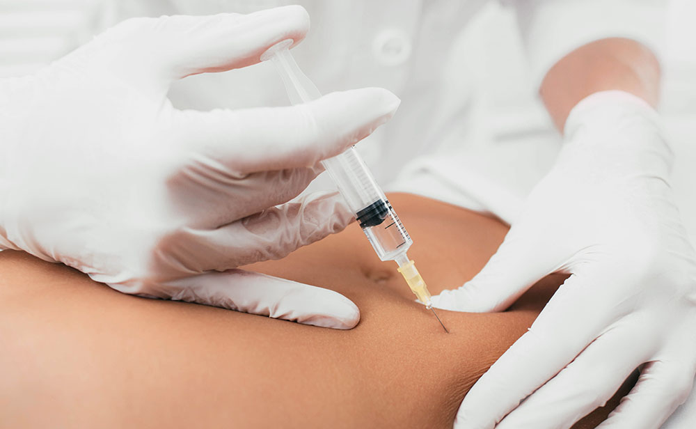 Injection into female belly,cellulite treatment. Beautician removing cellulite on the abdomen using beauty injections.