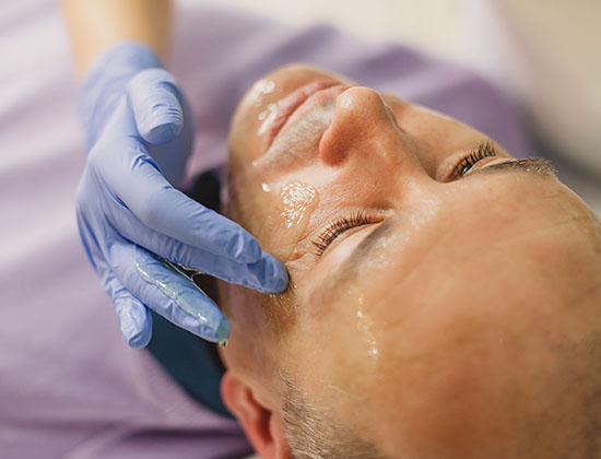 Relaxed man having a face massage and a peeling treatment at a beauty salon